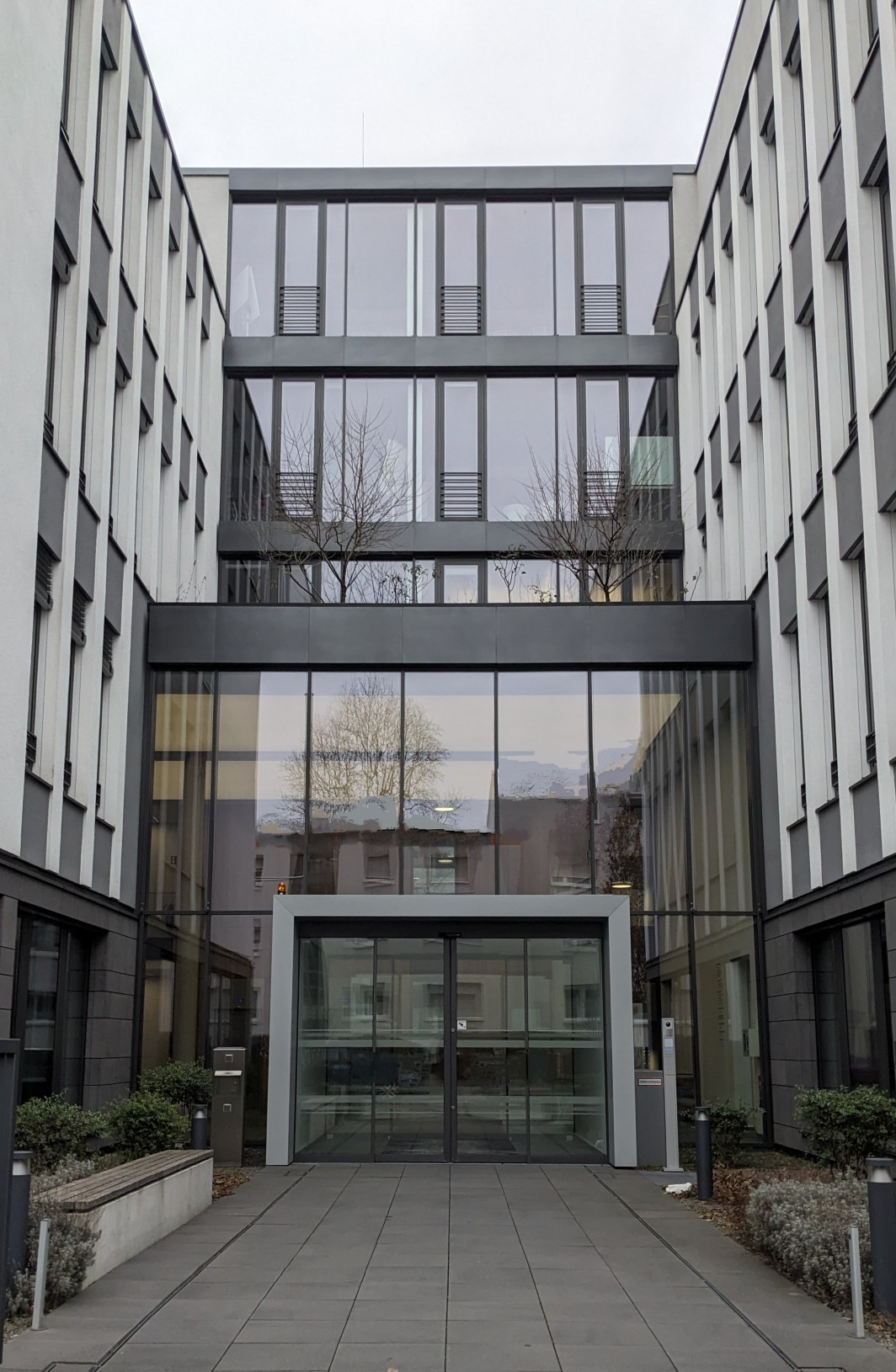 Eingang zum Gebäude in der Breitlacherstraße 92. Hohes Gebäude mit vielen Fenstern.